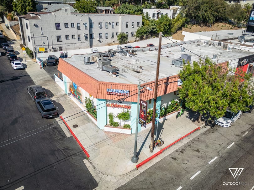 El Compadre Family Restaurant, a light blue building with an orange roof and murals, on a street corner.