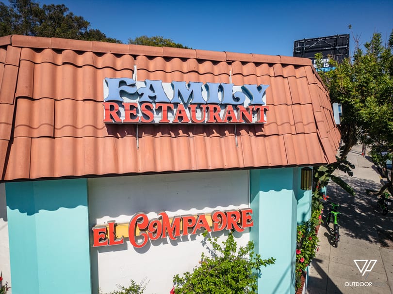 Exterior of El Compadre Family Restaurant with a red tiled roof and light blue walls.